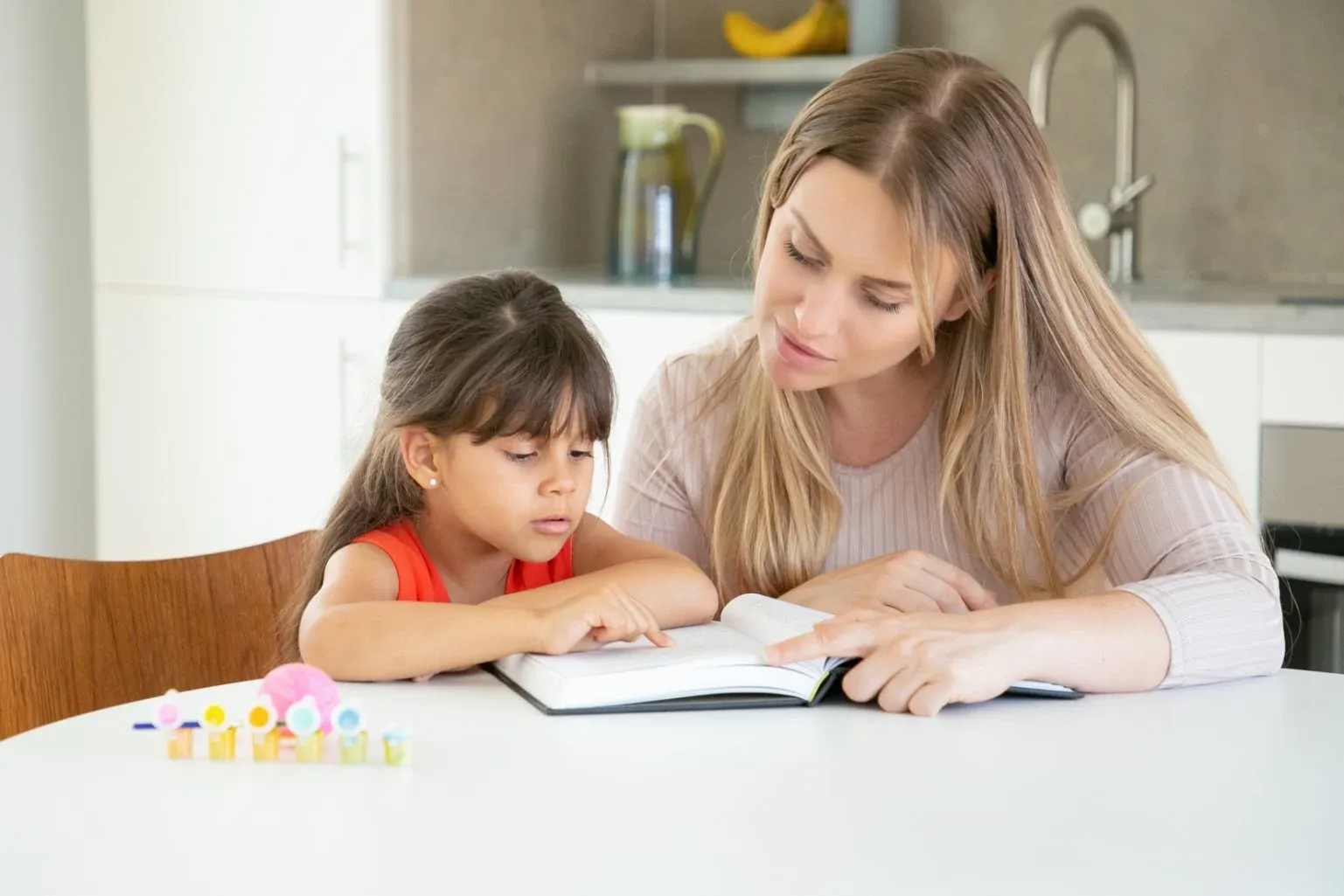 compressed_pretty-mom-reading-book-with-daughter-kitchen.webp